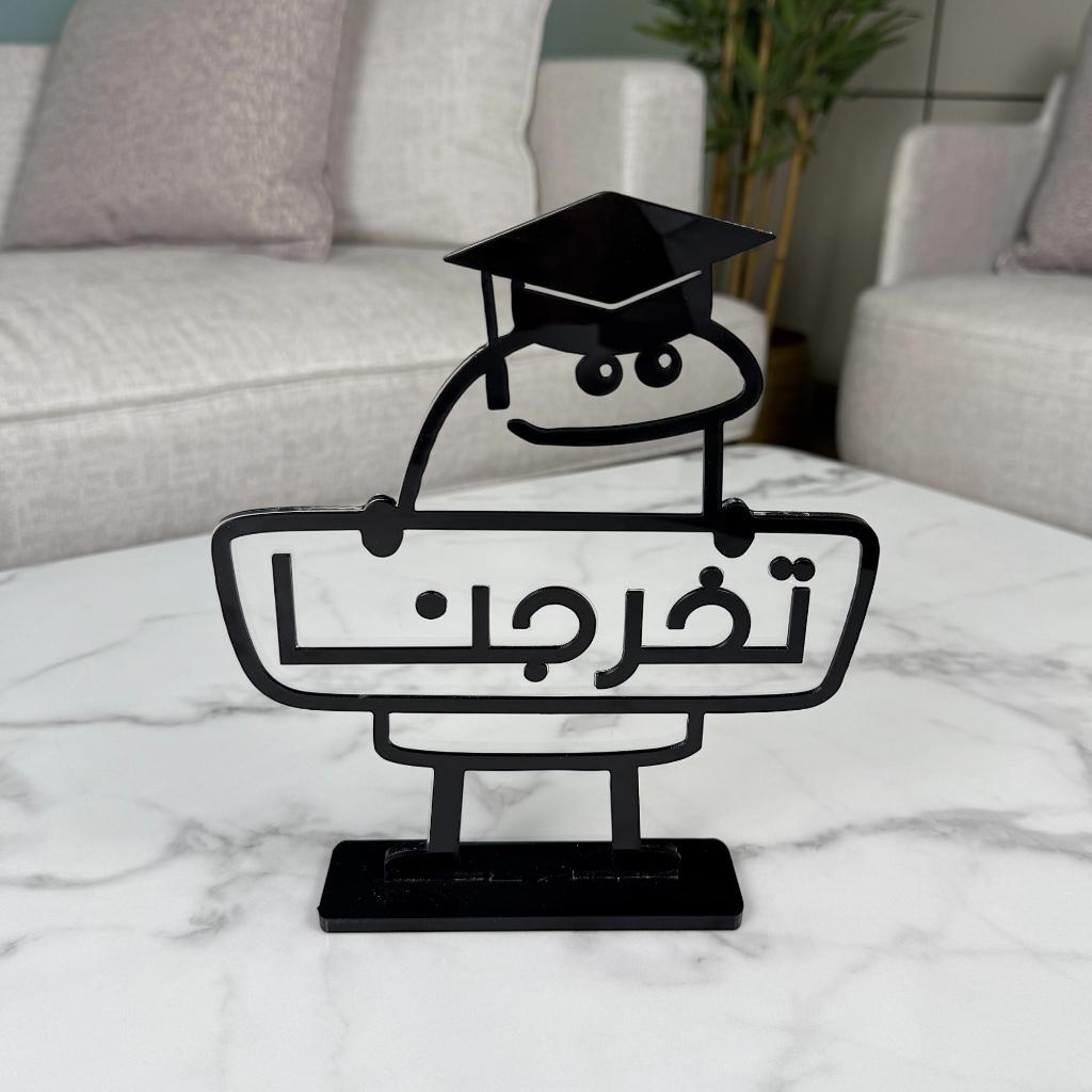 استاند أكريليك بتصميم كرتوني "تخرجنا" مع قبعة تخرج