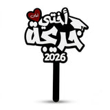 Black and white acrylic graduation topper reading "اختي احلى خريجة", suitable for flower bouquets and graduation photo props in UAE